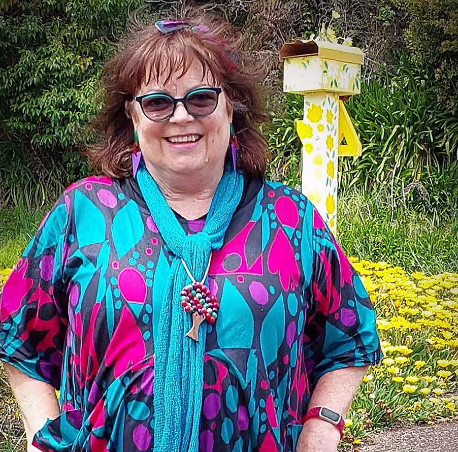 Sally Ewins smiling in a colourful outfit outdoors on Waiheke Island